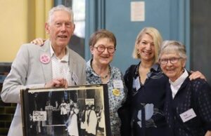 Professor Bernard Stewart, Dr Elaine Lindsay (national president 2022-), Professor Emerita Eileen Baldry AO (early Sydney MOW convenor), and The Rev’d Dr Sue Emeleus with a photo of the 1981 Anglican Women Concerned protest outside General Synod. CCSL hall, 17 September 2023.
